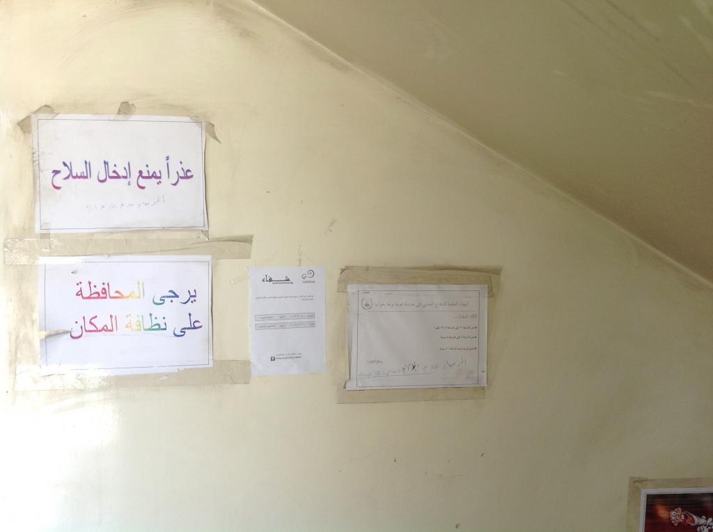 A sign inside the Civil Defence headquarters reads "Weapons are not allowed" - Photography by Razan Zeitouneh