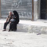 سيدة وزوجها ينتظران وسيلة نقل في حي السكري. تصوير حسام كويفاتية